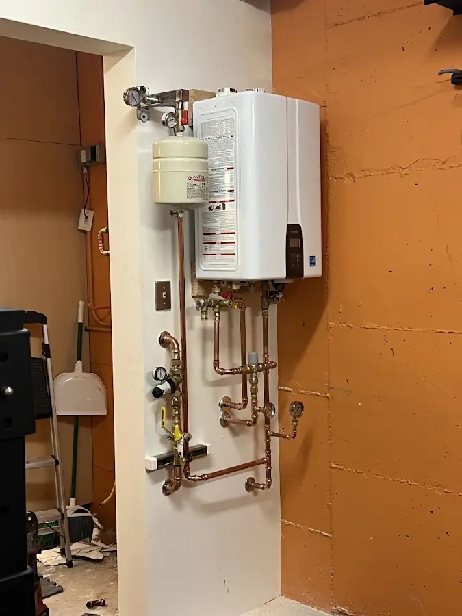Plumbing technician inspecting water heater connections in Druid Hills